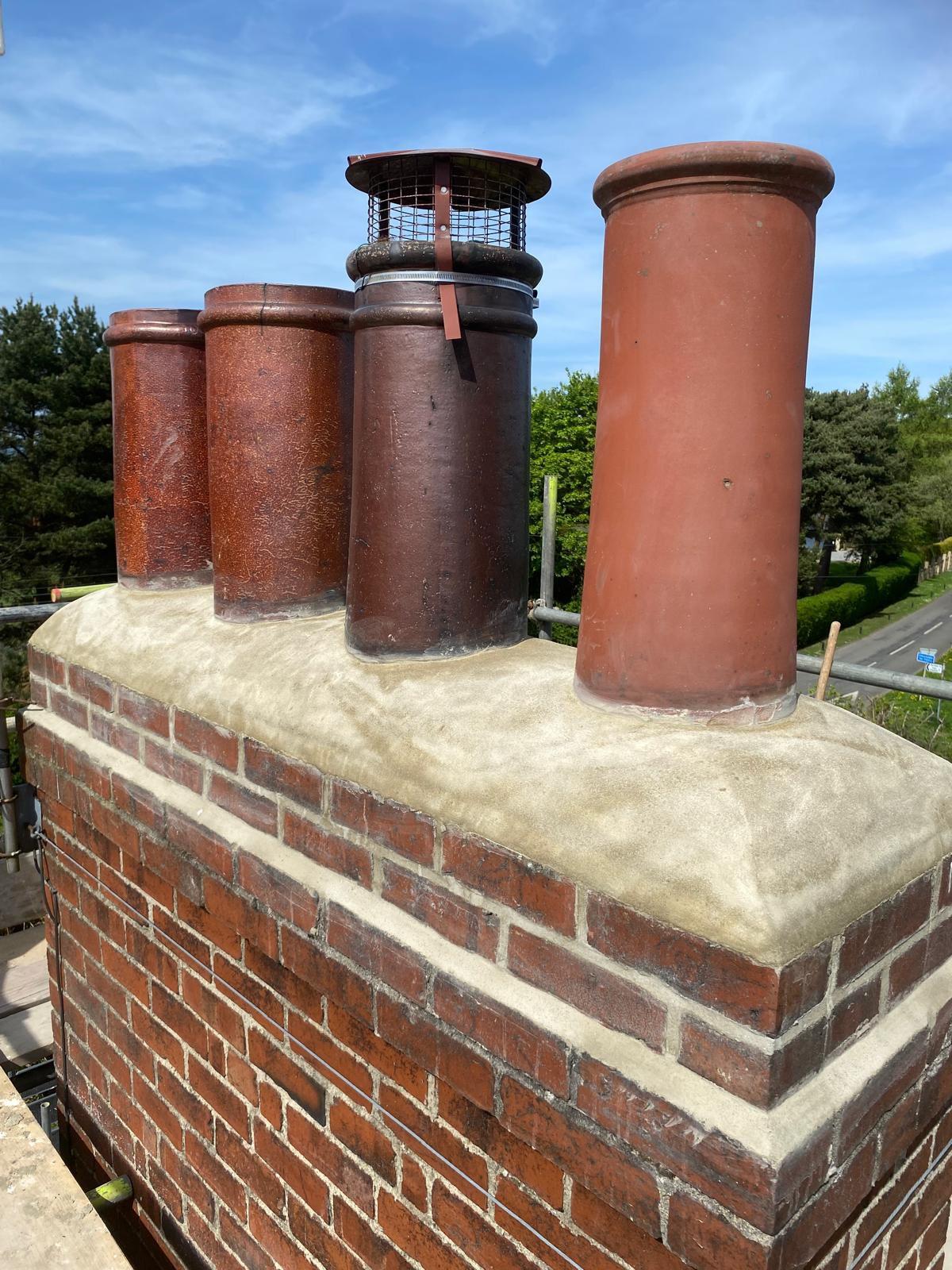 Chimney stack rebuild with multiple pots and fresh mortar haunching by APR Roofing